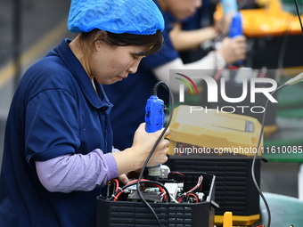 Workers work at a mobile energy storage power production workshop of an electric company in Fuyang, China, on September 26, 2024. (