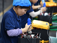 Workers work at a mobile energy storage power production workshop of an electric company in Fuyang, China, on September 26, 2024. (