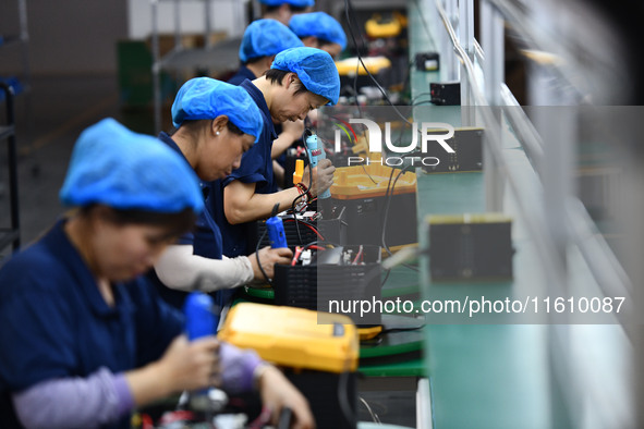 Workers work at a mobile energy storage power production workshop of an electric company in Fuyang, China, on September 26, 2024. 