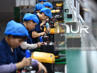 Workers work at a mobile energy storage power production workshop of an electric company in Fuyang, China, on September 26, 2024. (