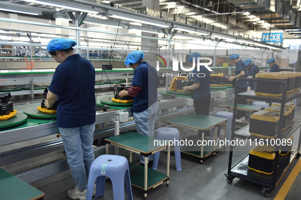 Workers work at a mobile energy storage power production workshop of an electric company in Fuyang, China, on September 26, 2024. 