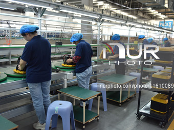 Workers work at a mobile energy storage power production workshop of an electric company in Fuyang, China, on September 26, 2024. (