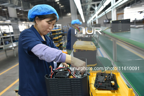 Workers work at a mobile energy storage power production workshop of an electric company in Fuyang, China, on September 26, 2024. 