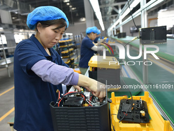 Workers work at a mobile energy storage power production workshop of an electric company in Fuyang, China, on September 26, 2024. (