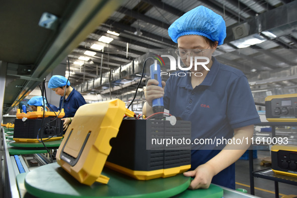 Workers work at a mobile energy storage power production workshop of an electric company in Fuyang, China, on September 26, 2024. 