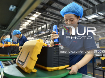 Workers work at a mobile energy storage power production workshop of an electric company in Fuyang, China, on September 26, 2024. (