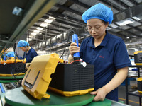 Workers work at a mobile energy storage power production workshop of an electric company in Fuyang, China, on September 26, 2024. (