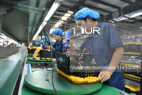 Workers work at a mobile energy storage power production workshop of an electric company in Fuyang, China, on September 26, 2024. 