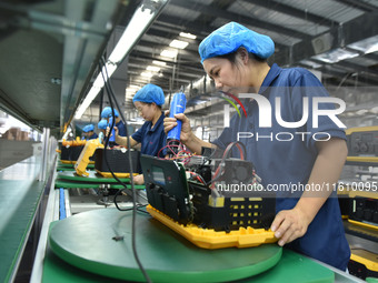 Workers work at a mobile energy storage power production workshop of an electric company in Fuyang, China, on September 26, 2024. (