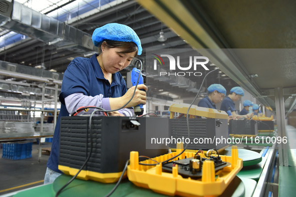 Workers work at a mobile energy storage power production workshop of an electric company in Fuyang, China, on September 26, 2024. 