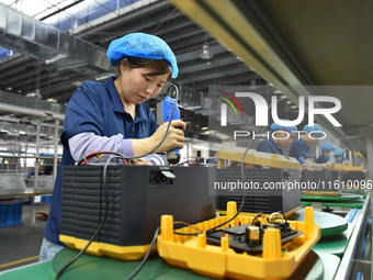 Workers work at a mobile energy storage power production workshop of an electric company in Fuyang, China, on September 26, 2024. (