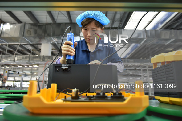 Workers work at a mobile energy storage power production workshop of an electric company in Fuyang, China, on September 26, 2024. 