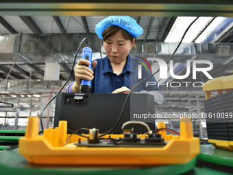 Workers work at a mobile energy storage power production workshop of an electric company in Fuyang, China, on September 26, 2024. (