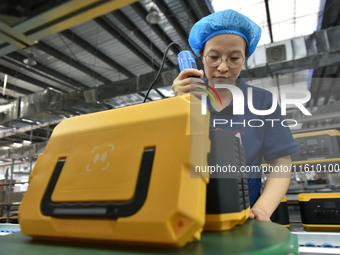 Workers work at a mobile energy storage power production workshop of an electric company in Fuyang, China, on September 26, 2024. (