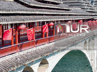 National flags are displayed on the Qiyan Bridge to celebrate China's National Day in Tongren, China, on September 26, 2024. (