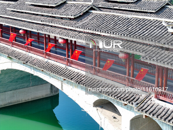 National flags are displayed on the Qiyan Bridge to celebrate China's National Day in Tongren, China, on September 26, 2024. 