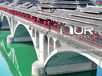 National flags are displayed on the Qiyan Bridge to celebrate China's National Day in Tongren, China, on September 26, 2024. (