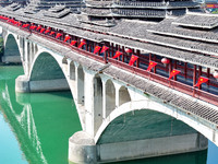 National flags are displayed on the Qiyan Bridge to celebrate China's National Day in Tongren, China, on September 26, 2024. (