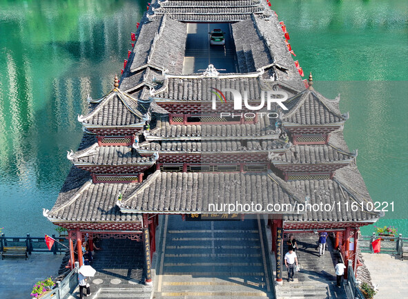 National flags are displayed on the Qiyan Bridge to celebrate China's National Day in Tongren, China, on September 26, 2024. 