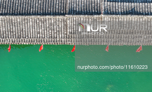 National flags are displayed on the Qiyan Bridge to celebrate China's National Day in Tongren, China, on September 26, 2024. 