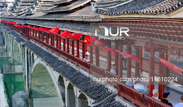 National flags are displayed on the Qiyan Bridge to celebrate China's National Day in Tongren, China, on September 26, 2024. 