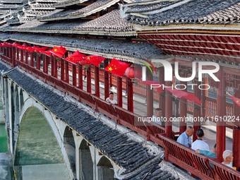 National flags are displayed on the Qiyan Bridge to celebrate China's National Day in Tongren, China, on September 26, 2024. (