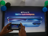 A man takes a picture of Apple's latest iPhone 16 billboard at Master Arts Shop in Srinagar, Jammu and Kashmir, on September 26, 2024. Accor...