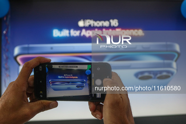 A man takes a picture of Apple's latest iPhone 16 billboard at Master Arts Shop in Srinagar, Jammu and Kashmir, on September 26, 2024. Accor...