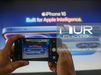 A man takes a picture of Apple's latest iPhone 16 billboard at Master Arts Shop in Srinagar, Jammu and Kashmir, on September 26, 2024. Accor...