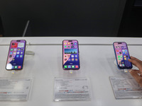 A customer checks Apple's latest iPhone 16 (right) series displayed for sale at Master Arts Shop in Srinagar, Jammu and Kashmir, on Septembe...