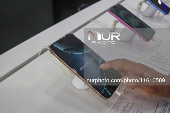 A customer checks Apple's latest iPhone 16 Pro Max series displayed for sale at Master Arts Shop in Srinagar, Jammu and Kashmir, on Septembe...