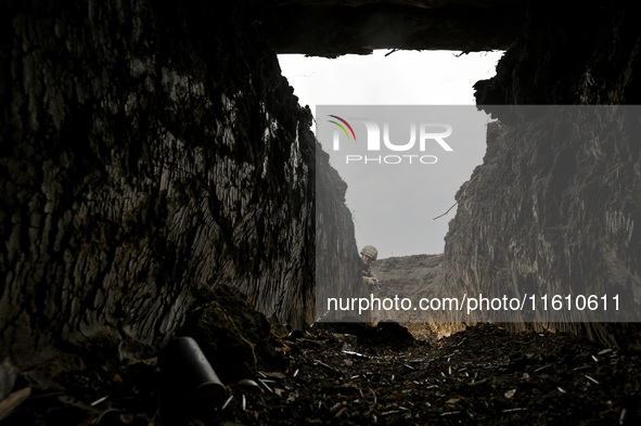 A serviceman of the 65th Separate Mechanized Brigade of the Armed Forces of Ukraine walks through the trenches during combat coordination in...