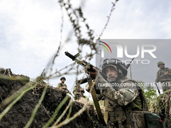 A serviceman of the 65th Separate Mechanized Brigade of the Armed Forces of Ukraine takes aim during combat cohesion in Ukraine, on Septembe...