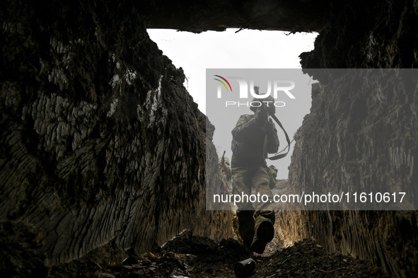 A serviceman of the 65th Separate Mechanized Brigade of the Armed Forces of Ukraine walks through the trenches during combat coordination in...