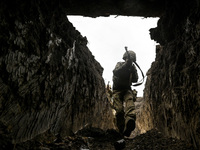 A serviceman of the 65th Separate Mechanized Brigade of the Armed Forces of Ukraine walks through the trenches during combat coordination in...