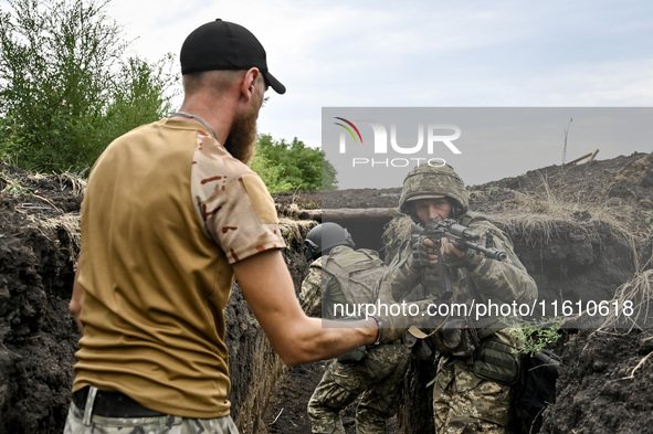 In Ukraine, on September 12, 2024, a combat training instructor (call sign ''Vokha'') (L) is pictured during the combat coordination of the...