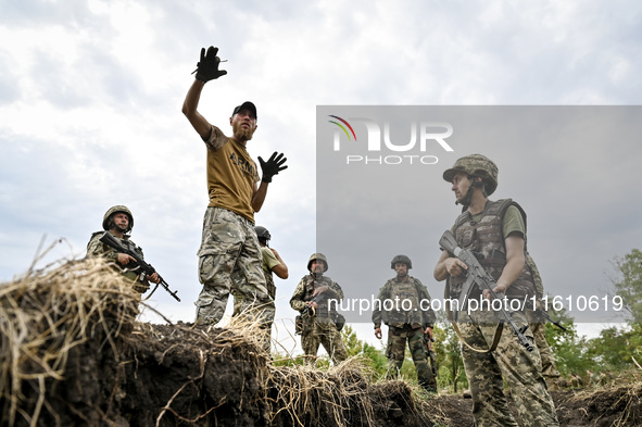 A combat training instructor (call sign ''Vokha'') (2nd L) is pictured during the combat coordination of the 65th Separate Mechanized Brigad...