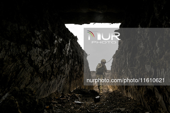 A serviceman of the 65th Separate Mechanized Brigade of the Armed Forces of Ukraine walks through the trenches during combat coordination in...