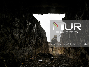 A serviceman of the 65th Separate Mechanized Brigade of the Armed Forces of Ukraine walks through the trenches during combat coordination in...