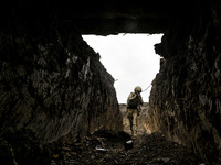 A serviceman of the 65th Separate Mechanized Brigade of the Armed Forces of Ukraine walks through the trenches during combat coordination in...