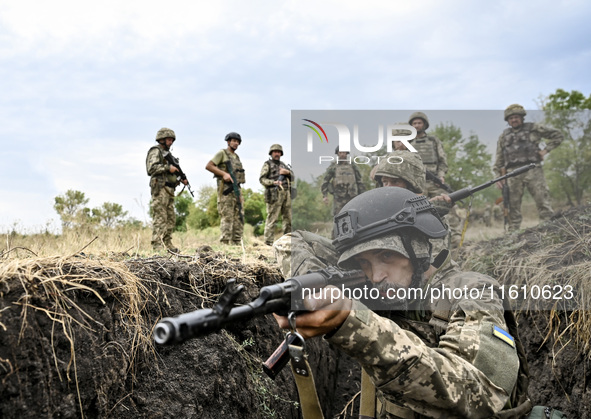 A serviceman of the 65th Separate Mechanized Brigade of the Armed Forces of Ukraine takes aim during combat cohesion in Ukraine, on Septembe...