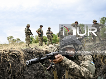 A serviceman of the 65th Separate Mechanized Brigade of the Armed Forces of Ukraine takes aim during combat cohesion in Ukraine, on Septembe...