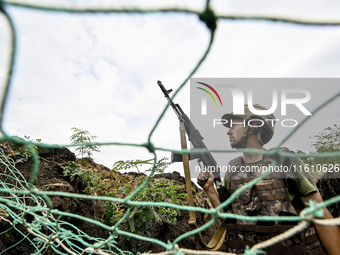 A serviceman of the 65th Separate Mechanized Brigade of the Armed Forces of Ukraine is seen through the net during combat coordination in Uk...