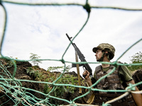 A serviceman of the 65th Separate Mechanized Brigade of the Armed Forces of Ukraine is seen through the net during combat coordination in Uk...