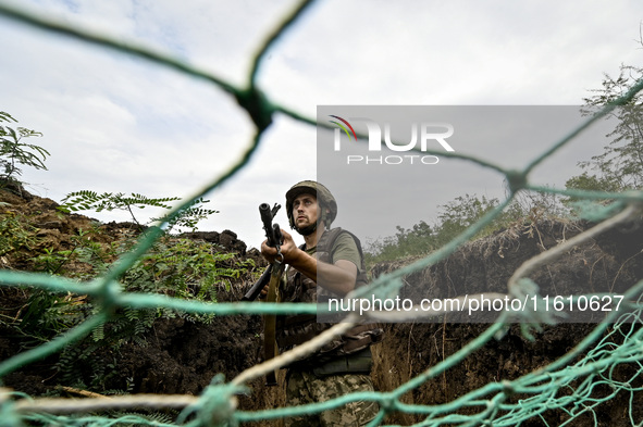 A serviceman of the 65th Separate Mechanized Brigade of the Armed Forces of Ukraine is seen through the net during combat coordination in Uk...