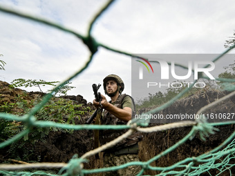 A serviceman of the 65th Separate Mechanized Brigade of the Armed Forces of Ukraine is seen through the net during combat coordination in Uk...