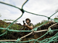 A serviceman of the 65th Separate Mechanized Brigade of the Armed Forces of Ukraine is seen through the net during combat coordination in Uk...