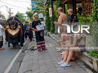 A group of children is seen performing Ngelawang, a traditional ritual featuring the Barong Bangkung, a barong with the head of a wild boar,...