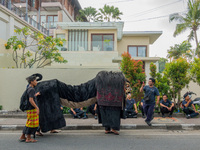 A group of children is seen performing Ngelawang, a traditional ritual featuring the Barong Bangkung, a barong with the head of a wild boar,...