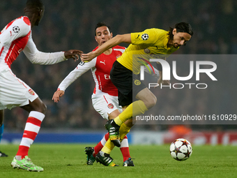 Santi Cazorla of Arsenal competes for the ball with Neven Subotic of Borussia Dortmund during the UEFA Champions League Group D soccer match...